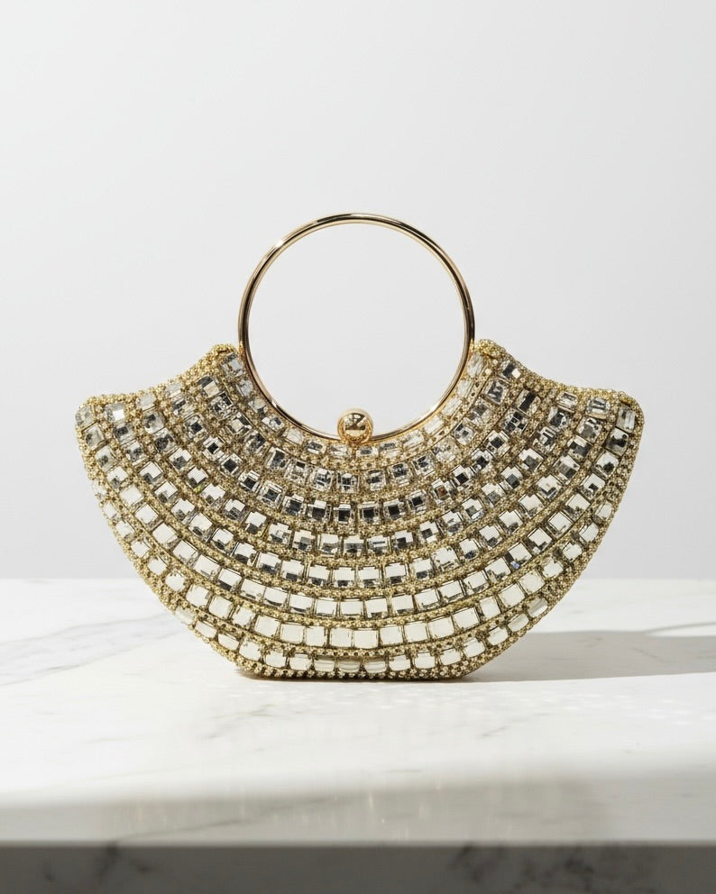 Gold beaded handbag on a marble surface with a white background