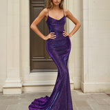 Woman wearing a purple lace up back glitter formal evening gown in front of classical architecture.
