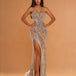 A woman models a strapless floor-length evening gown with a sweetheart neckline, high thigh slit, and dramatic cascading sequin detailing in gold, silver, and light blue on a warm beige background.