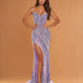 A woman modeling a strapless lavender and silver sequined floor-length gown with a sweetheart neckline, thigh-high slit, and slight train against a warm tan studio backdrop.