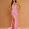 A woman models a strapless pink evening gown with silver sequin embellishments, a sweetheart neckline, and a high thigh slit, set against a solid tan studio background.
