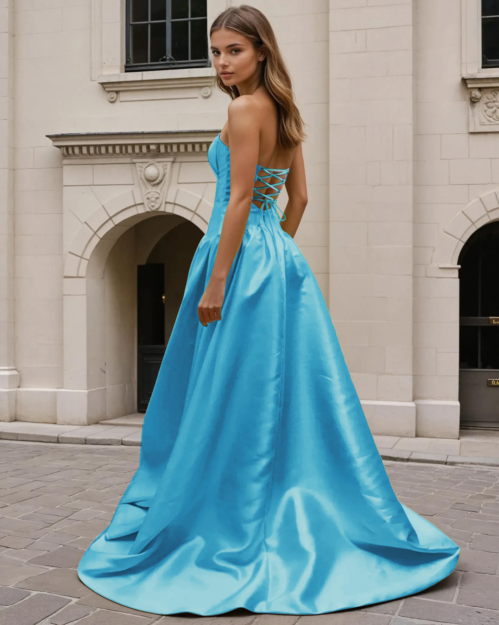 Woman wearing a blue formal strapless gown standing on a stone pavement.