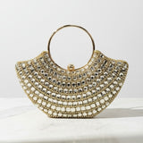 Gold beaded handbag on a marble surface with a white background