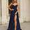Woman wearing a navy blue formal dress glitter evening gown with a high slit in an urban setting.