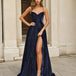 Woman wearing a navy blue formal dress glitter evening gown with a high slit in an urban setting.