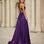 Woman in a purple evening dress formal a-line gown standing in front of classical architecture.