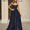 Woman wearing a navy a-line strapless glitter formal evening gown in front of classical architecture.