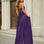 Woman wearing a purple a-line strapless glitter formal evening gown in front of classical architecture.