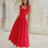 Woman in a red midi dress standing in front of classical architecture