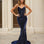 Woman wearing a navy blue glitter formal evening gown in front of classical architecture.