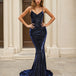 Woman wearing a navy blue glitter formal evening gown in front of classical architecture.