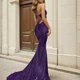 Woman wearing a purple lace up back glitter formal evening gown in front of classical architecture.